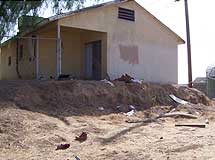 Derelict home on a dirt lot.